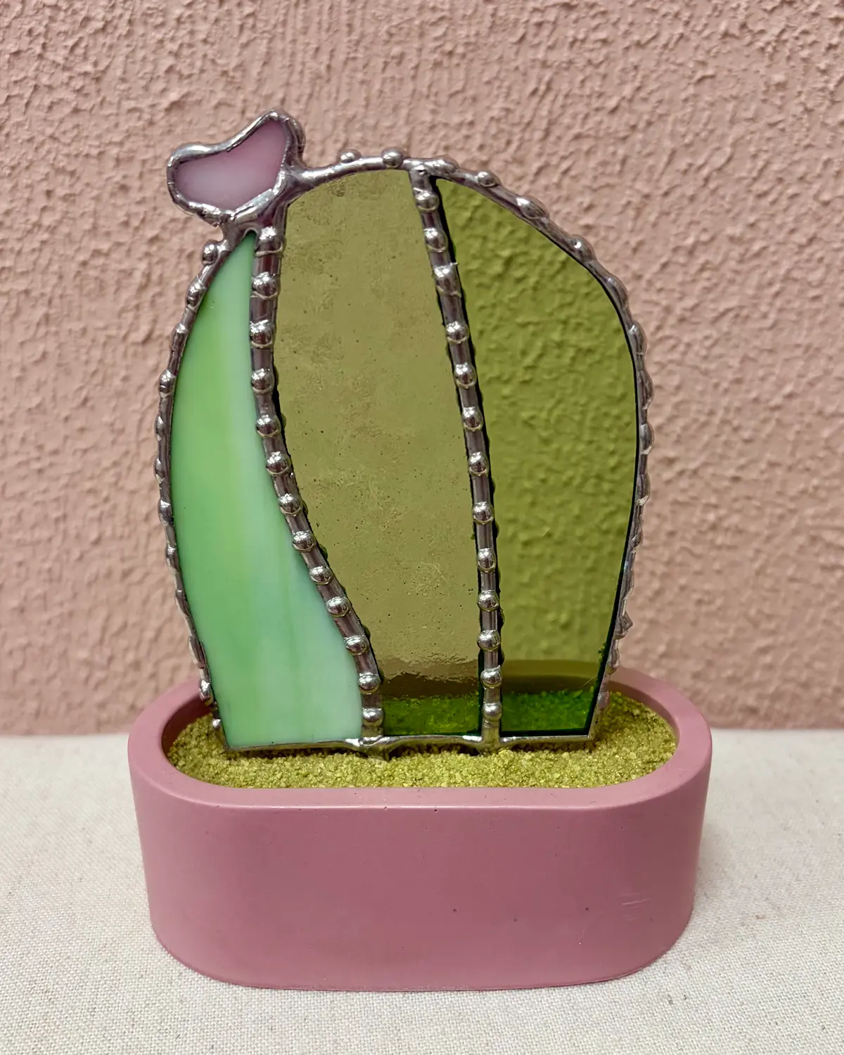 Glazen cactusjes met bloemen in verschillende kleuren en handgemaakte potjes